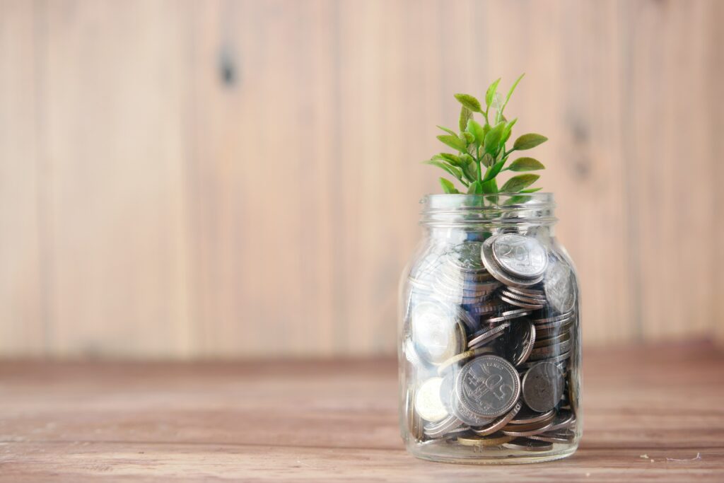 A jar full of coins and a small plant
